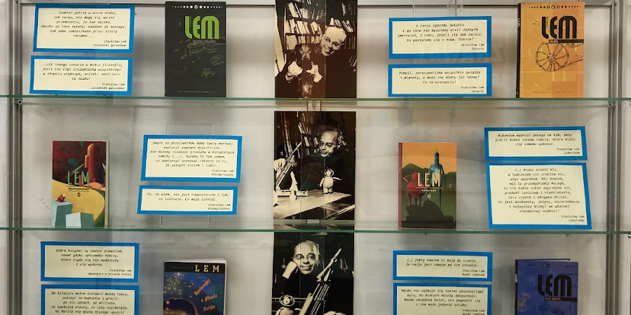 Gablota zawierająca sześć książek autorstwa Lema opatrzonych cytatami. Po środku pionowo trzy zdjęcia Stanisława Lema
