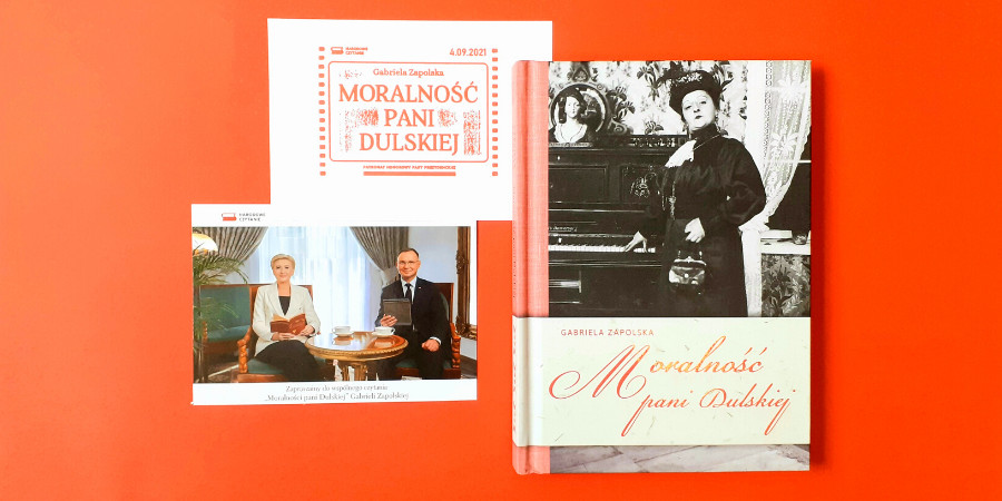 Na czerwonym tle zdjęcie Pary Prezydenckiej RP, okładka książki "Moralność Pani Dulskiej" oraz pieczątka promująca akcję Narodowe Czytanie
