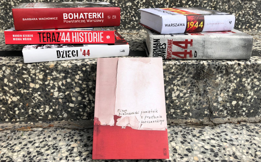 Sześć książek poświęconych Powstaniu Warszawskiemu na kamiennych schodach wejściowych do biblioteki.