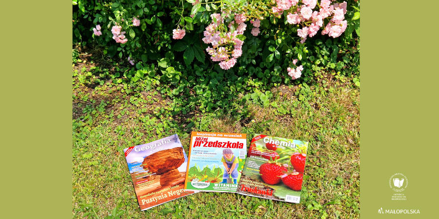 Na trawniku przy krzaczku z różowymi kwiatkami leżą 3 czasopisma pedagogiczne: Geografia w Szkole, Bliżej przedszkola i Chemia w Szkole