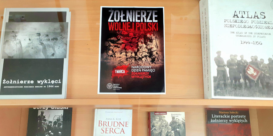 W gablocie, na półkach ułożone frontem książki dotyczące Żołnierzy Wyklętych. Na samej plakat informujący o Narodowym Dniu Pamięci Żołnierzy Wyklętych.