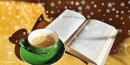 Na żółtym fotelu zielona filiżanka z kawą oraz otwarta książka, w tle białe śnieżynki.