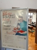 Plakat promujący konferencję, w tle sala wykładowa