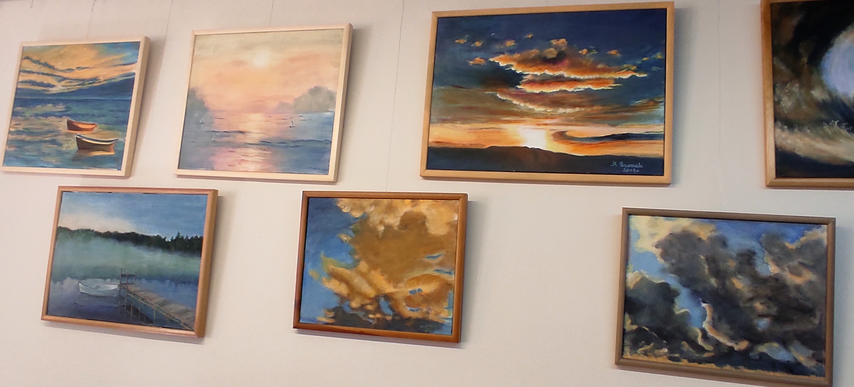 Obrazy przedstawiające morze, jeziora i chmury w kolorach beżowych, niebieskich, granatowych, oprawione w ramy