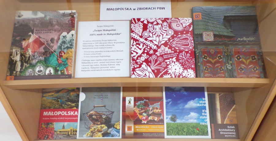 Na 4 półkach okładki książek o Małopolsce. U góry napis "Małopolska w zbiorach PBW.