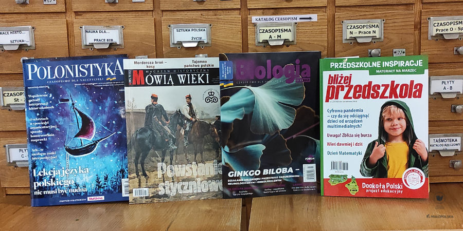 Cztery okładki recenzowanych czasopism pedagogicznych na tle bibliotecznej szafy katalogowej.