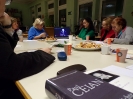 Widok na leżący na stole tomik poezji nad którym rozpościera się widok na pięć uczestniczek oglądających na laptopie archiwalny film z odczytem Paula Celana.