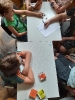 Przy stoliku siedzą dzieci, jeden chłopiec rzuca kością opowieści