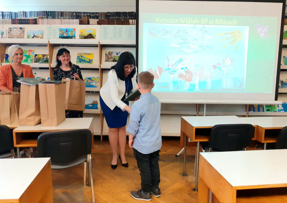 Pani Dyrektor Biblioteki Anna Piotrowska gratuluje chłopcu zajęcia I miejsca w konkursie