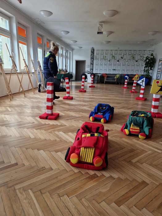 Pani ze Straży Miejskiej miasta Krakowa rozkłada elementy miasteczka drogowego w holu Biblioteki