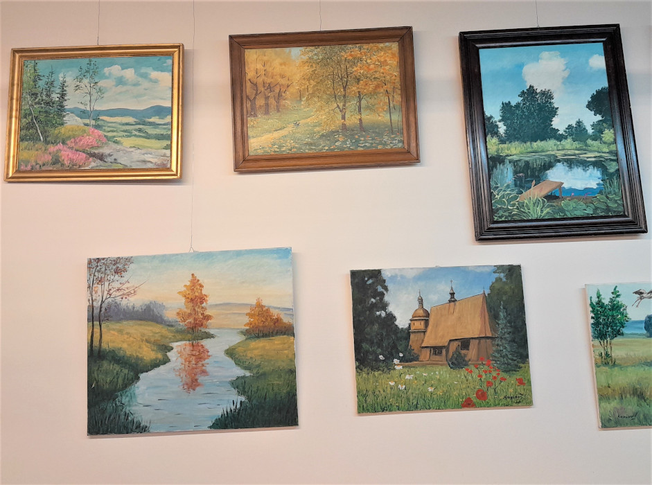 Obrazy na ścianie przedstawiające sielskie krajobrazy.