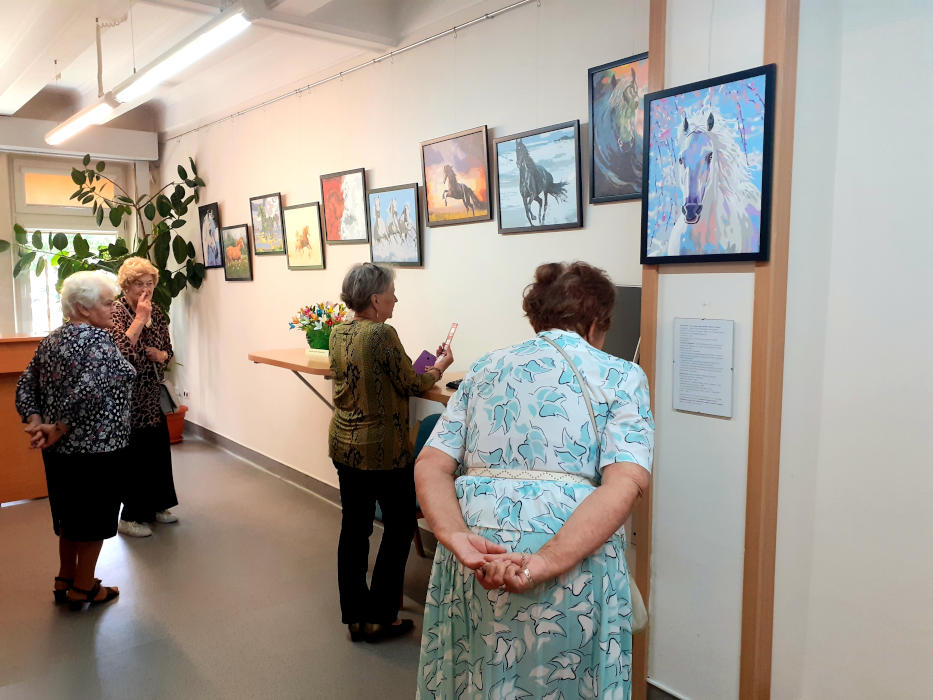 4 kobiety podziwiające wystawę obrazów w Wypożyczalni.