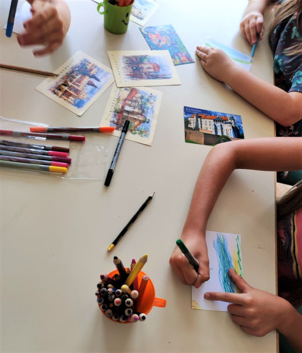 Ręce dzieci rysujących kartki pocztowe z Krakowa