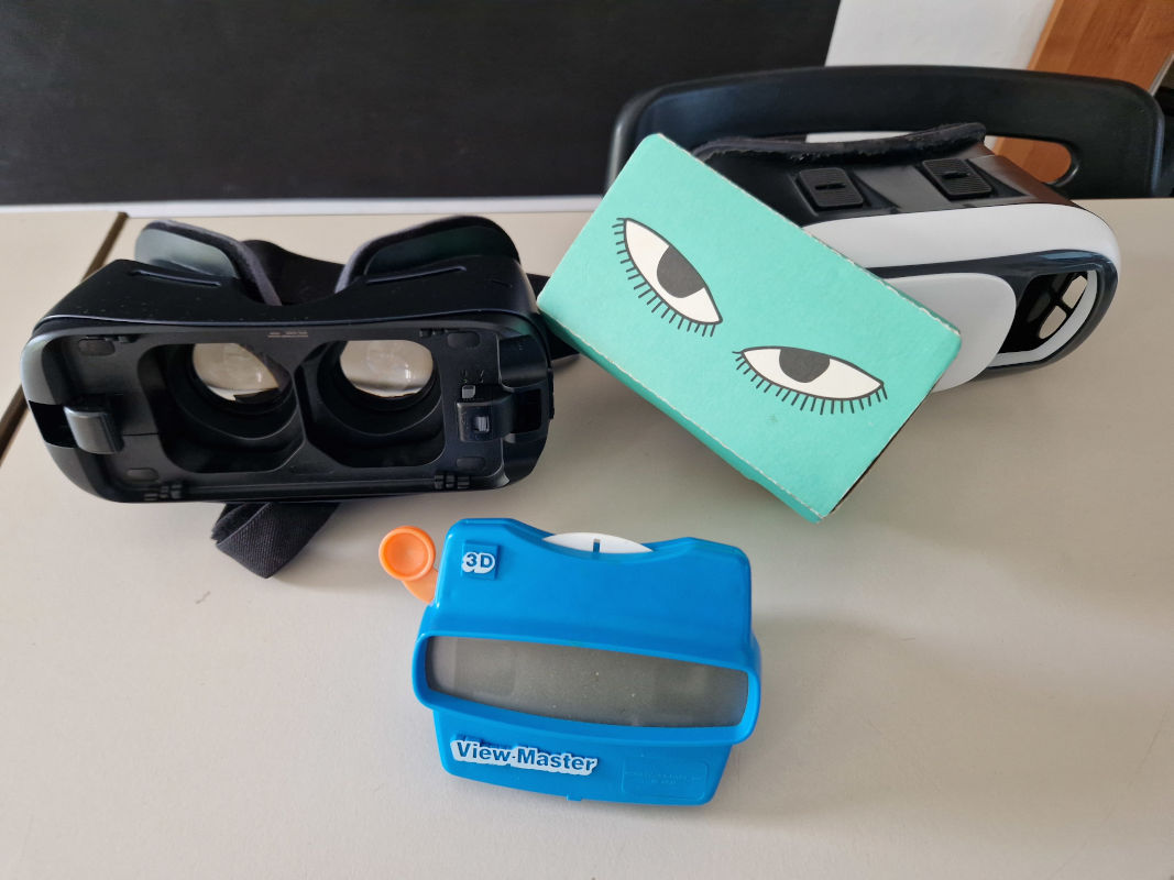 Na stole leżące różne rodzaje okularów i gogli VR.